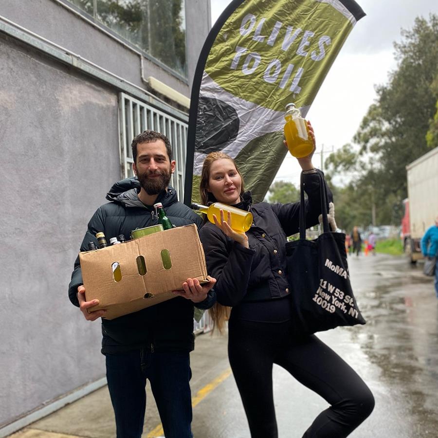Local folks pose for a photo while collecting their community olive oil - CERES Olives to Oil.