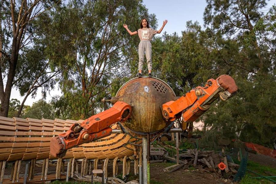 A child stands high on the head of the Millipede playground sculpture, CERES Brunswick